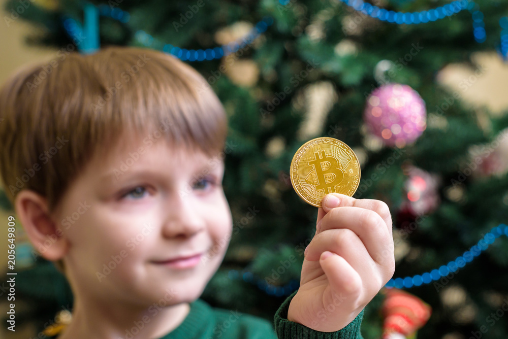 One Bitcoin in the hand of young boy. Concept. Crypto digital gold One Bitcoin in the hand of young boy. Concept. Crypto digital gold