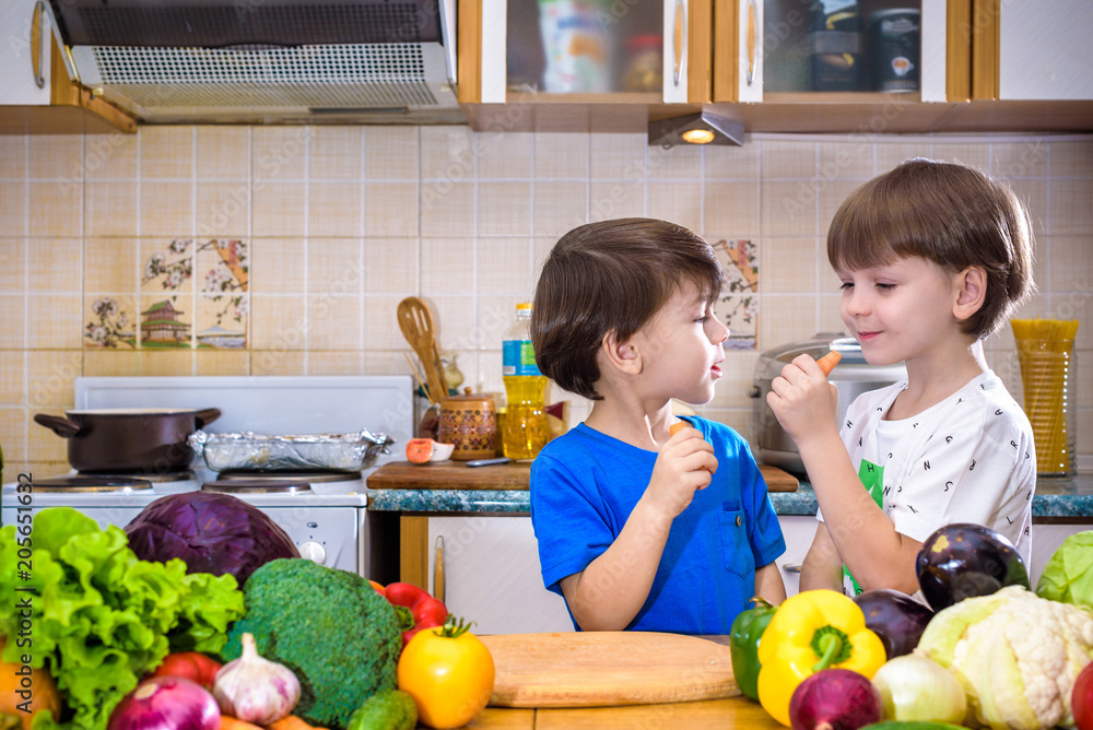 Healthy eating. Happy children prepares and eats vegetable salad in kitchen Healthy eating. Happy children prepares and eats vegetable salad in kitchen