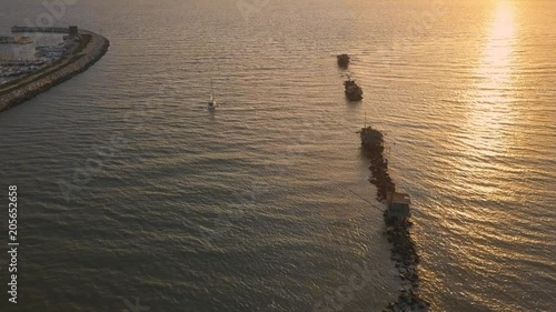 Vista aerea di sagome dei trabucchi sul mare per la pesca del pesce con pescatori alle ultime luci del tramonto. photo