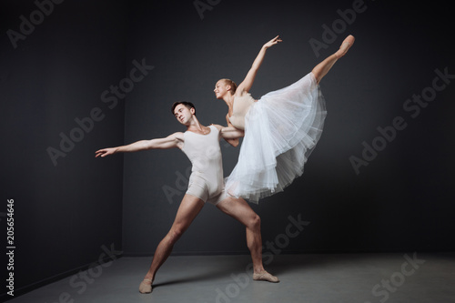 Young reliable dancer standing and supporting his partner.