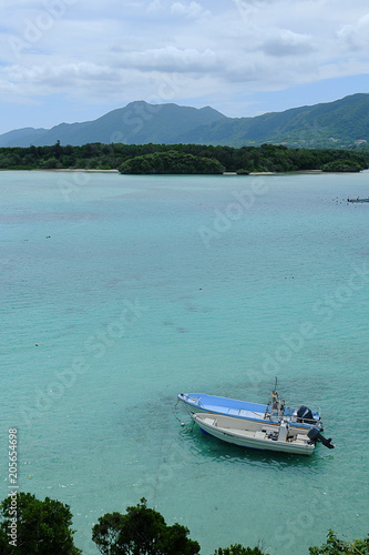 Two boats anchoring in crystal clear turquoise water.