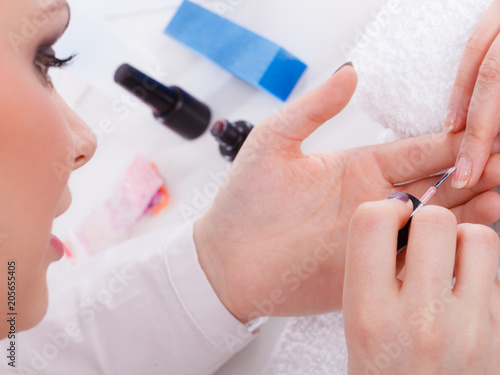 Woman in beauty salon getting manicure done.