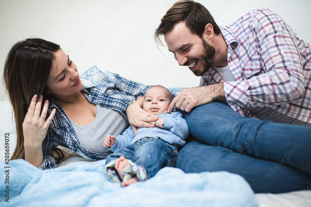 Mother and father enjoying and relaxing with their baby boy.