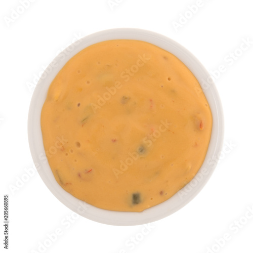 Top view of melted dipping cheese in a small bowl isolated on a white background.