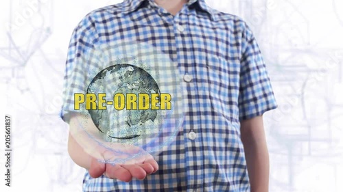 Young man shows a hologram of the planet Earth and text Pre order. Boy with future technology 3d projection on a modern white digital background photo