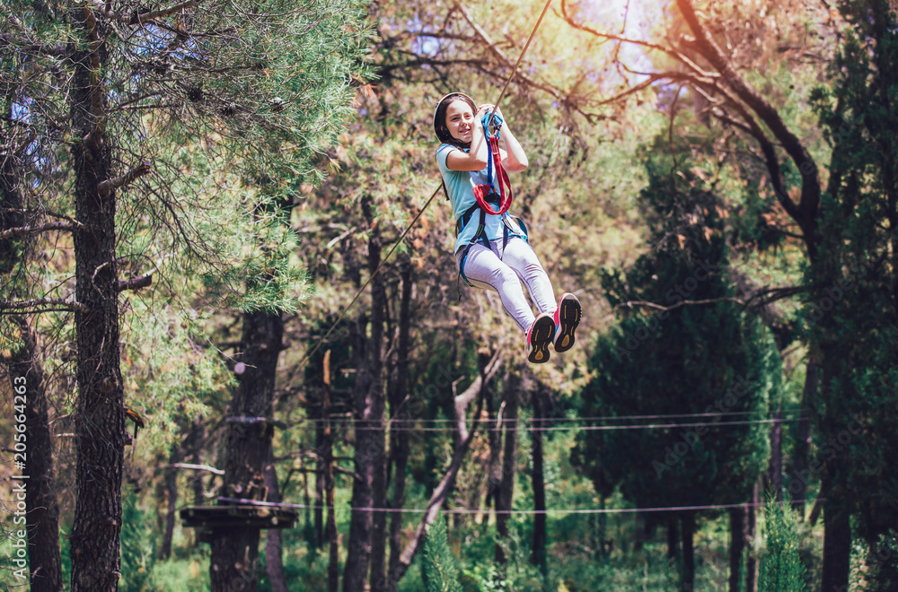 Happy school girl enjoying activity in a climbing adventure park on a summer day Happy school girl enjoying activity in a climbing adventure park on a summer day