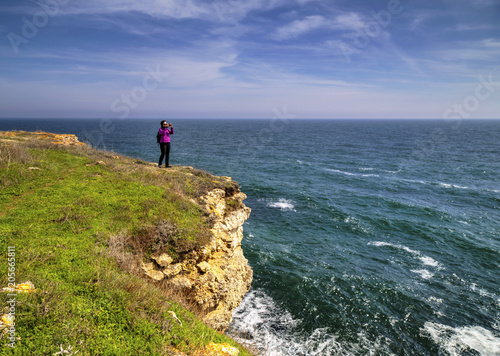 Young lady taking beautiful landscape pictures in the nature