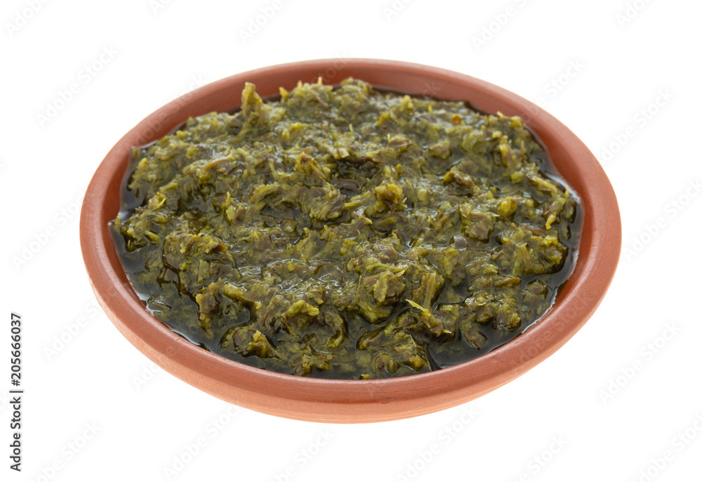 Bowl of chopped parsley in canola oil on a white background. Bowl of chopped parsley in canola oil on a white background.
