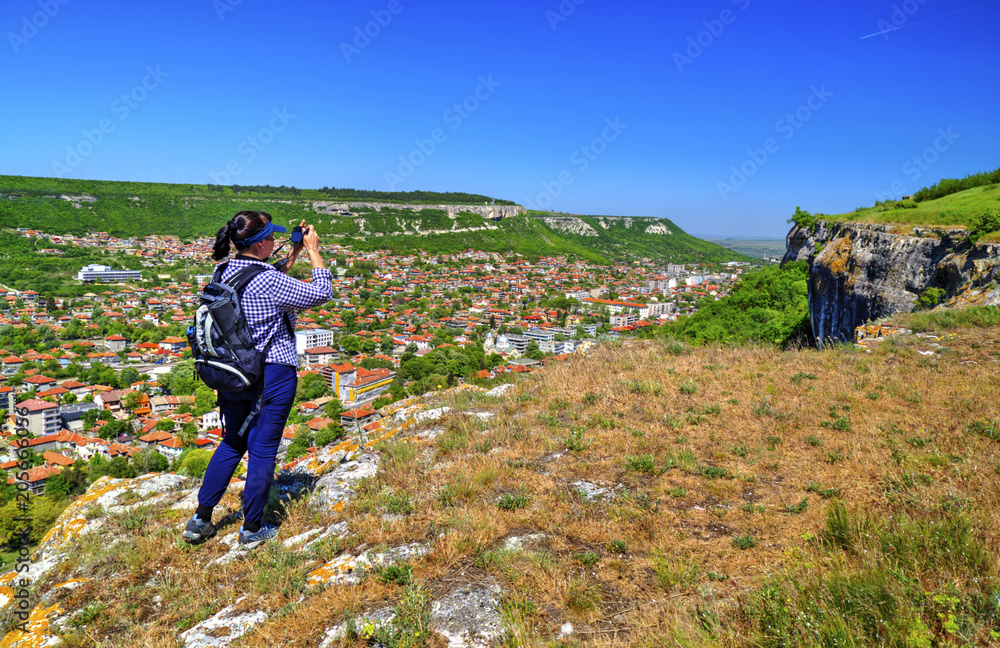 Young lady taking beautiful landscape pictures in the nature