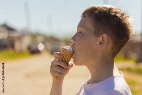 teen boy enjoying eating ice cream outdoors 