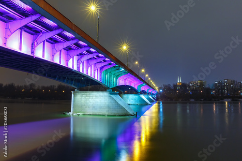 Christmas lighting of Slasko-Dabrowski Bridge in Old Town with reflection in the Vistula River at night, Warsaw, Poland.