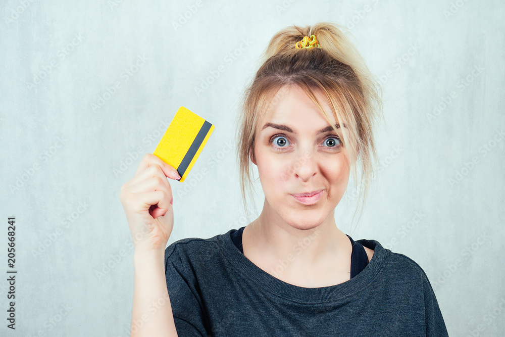 Portrait of a young and beautiful blonde holding a credit card in her hand. concept of shopping and credit Portrait of a young and beautiful blonde holding a credit card in her hand. concept of shopping and credit