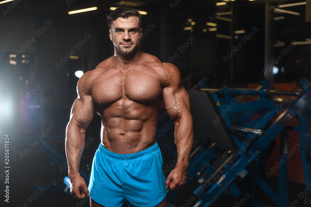 Handsome model muscle man abs workout in gym Handsome model muscle man abs workout in gym