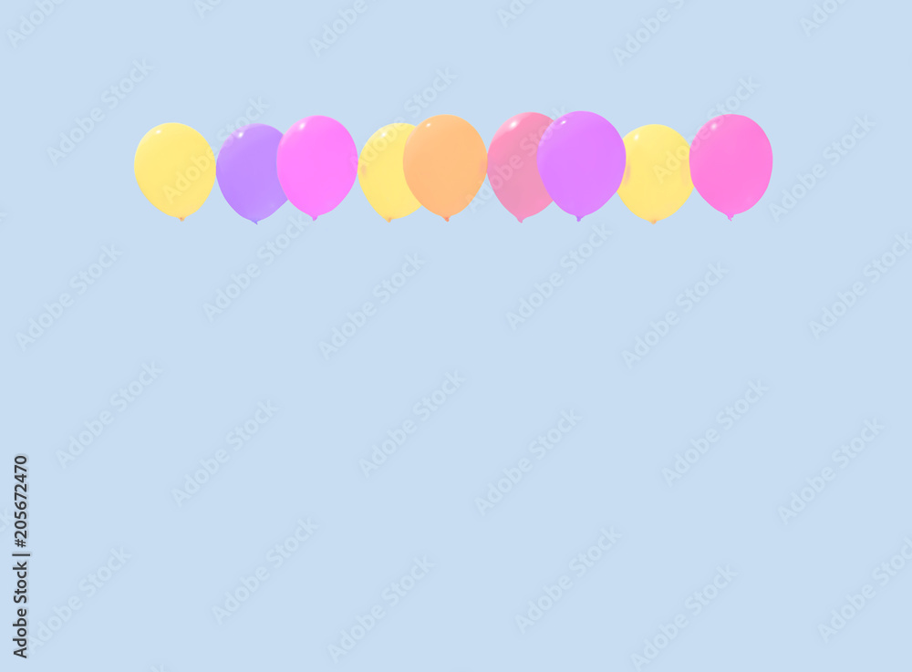 Colourful faded balloons yellow pink purple red soaring against light blue sky with copy space.
