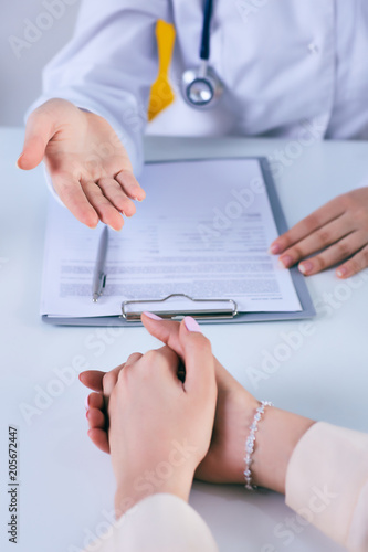 Фотография Female doctor giving a consultation to a patient and explaining medical informations and diagnosis