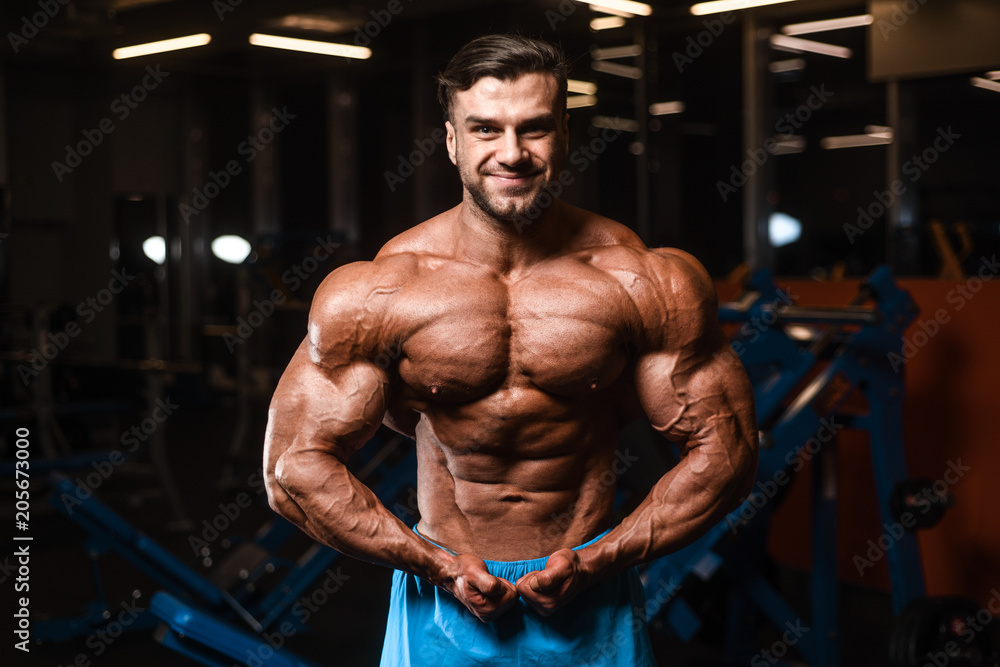 Handsome model muscle man abs workout in gym Handsome model muscle man abs workout in gym