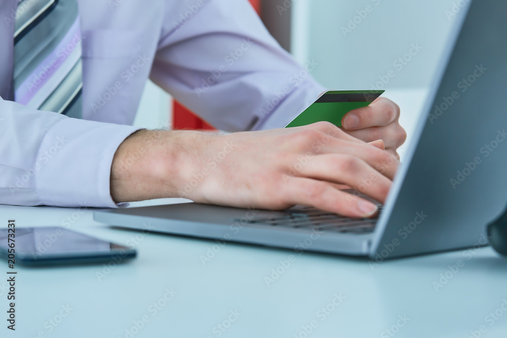 Man's hands holding a credit card and using smart phone for online shopping. Online payment Man's hands holding a credit card and using smart phone for online shopping. Online payment