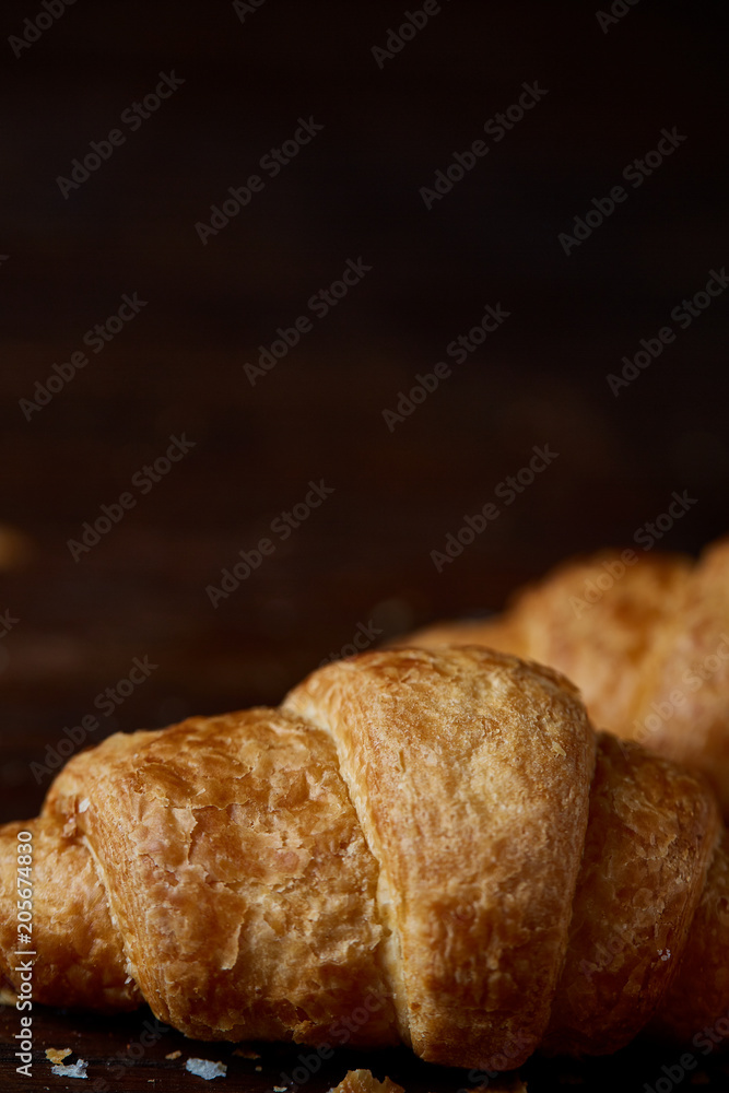 Tasty buttery croissants on an old wooden table, close-up, selective focus, shallow depth of field. Tasty buttery croissants on an old wooden table, close-up, selective focus, shallow depth of field.