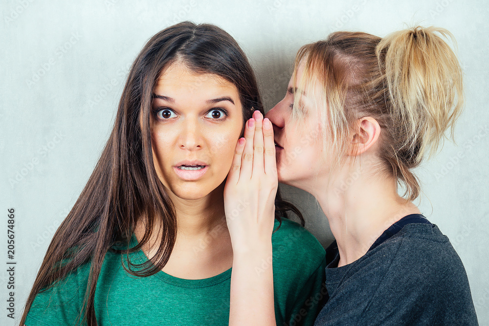 two beautiful and young girlfriends women gossip. the concept of eavesdropping and gossip two beautiful and young girlfriends women gossip. the concept of eavesdropping and gossip