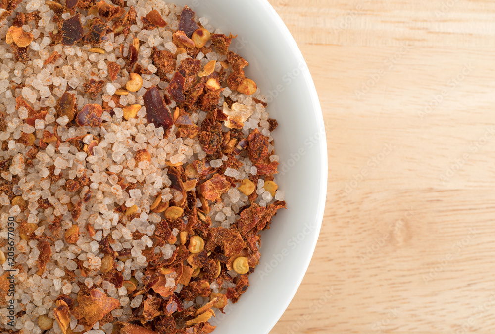 Top close view of Greek spice rub in a white bowl atop a wood table. Top close view of Greek spice rub in a white bowl atop a wood table.