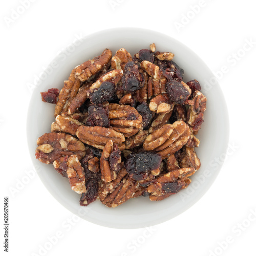 Top view of sugar glazed pecans with dried cranberries in a white bowl.