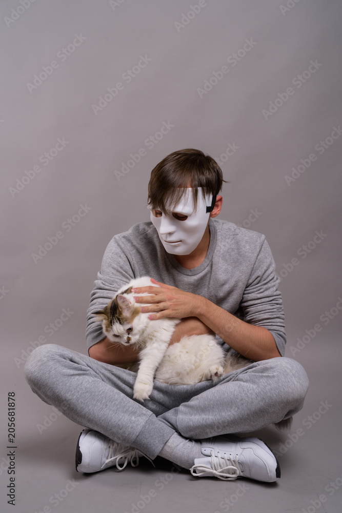 Obraz premium Young handsome man wearing white mask against gray background