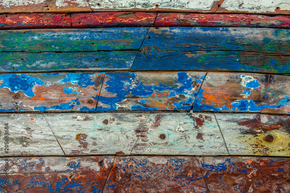 Surface of old and worn out wooden panels painted in several colours with the apaint peeling off Surface of old and worn out wooden panels painted in several colours with the apaint peeling off