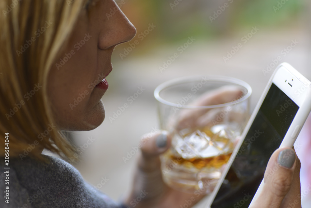 Woman tasting an appetizer while looking at her cell phone Woman tasting an appetizer while looking at her cell phone