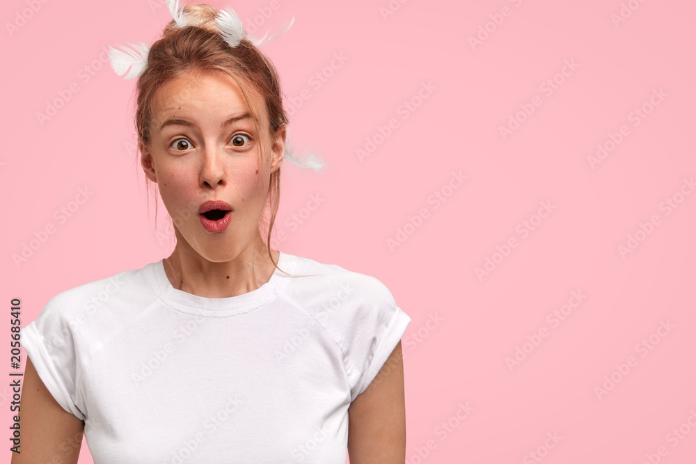 Horizontal portrait of surprised young Caucasian woman has shocked