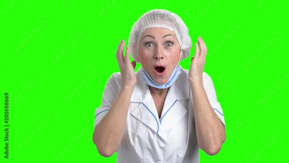 Surprised doctor woman on green screen. Happy delighted female doctor in cap and mask looking surprised on chroma key background. Surprised doctor woman on green screen. Happy delighted female doctor in cap and mask looking surprised on chroma key background.