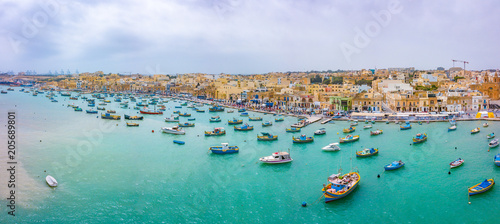 Traditional eyed colorful boats Luzzu in the Harbor of Mediterranean fishing village Marsaxlokk, Malta photo