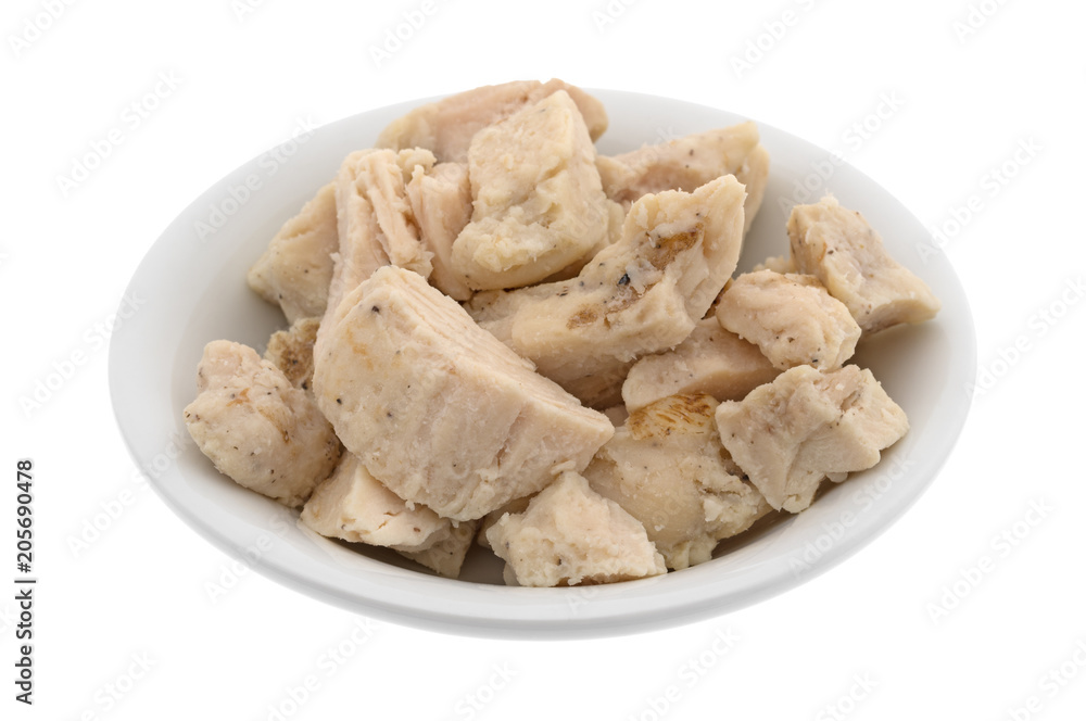 Chicken breast chunks in a small bowl isolated on a white background. Chicken breast chunks in a small bowl isolated on a white background.