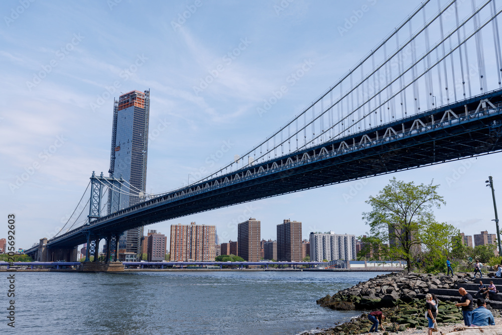 Naklejka premium Widok z boku konstrukcji mostu Manhattan i budynków w Nowym Jorku