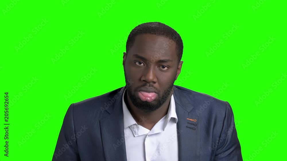 Funny afro-american businessman on green screen. Cheerful dark-skinned guy in formal wear twinkling with eye and showing tongue on chroma key background. Funny afro-american businessman on green screen. Cheerful dark-skinned guy in formal wear twinkling with eye and showing tongue on chroma key background.