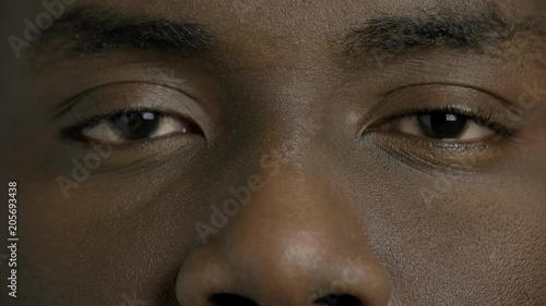 Close up dark-skinned man closed eyes. Afro-american male person is openes his eyes close up. Black man eyes. photo