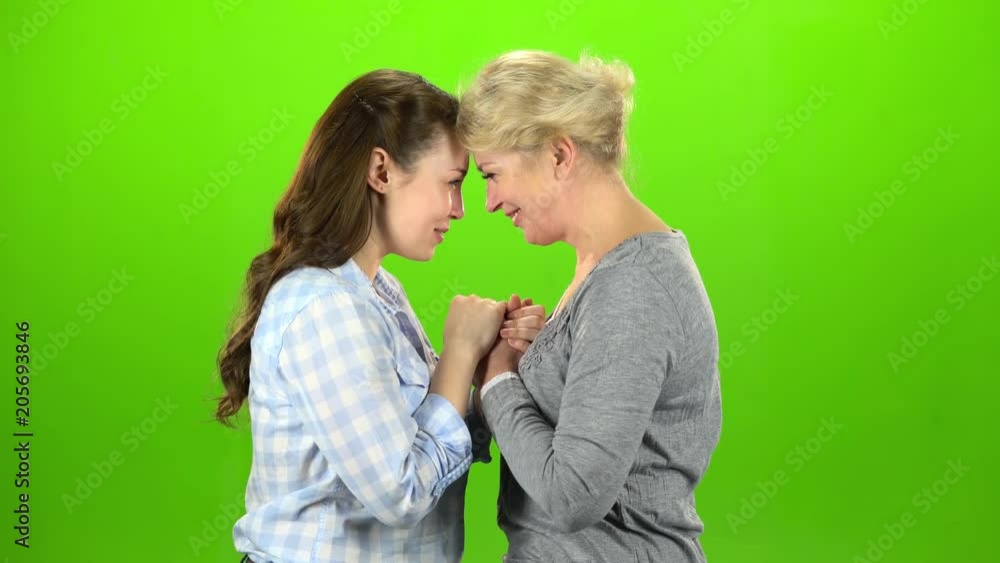 Mom and daughter talking on various topics. Green screen. Side view Mom and daughter talking on various topics. Green screen. Side view