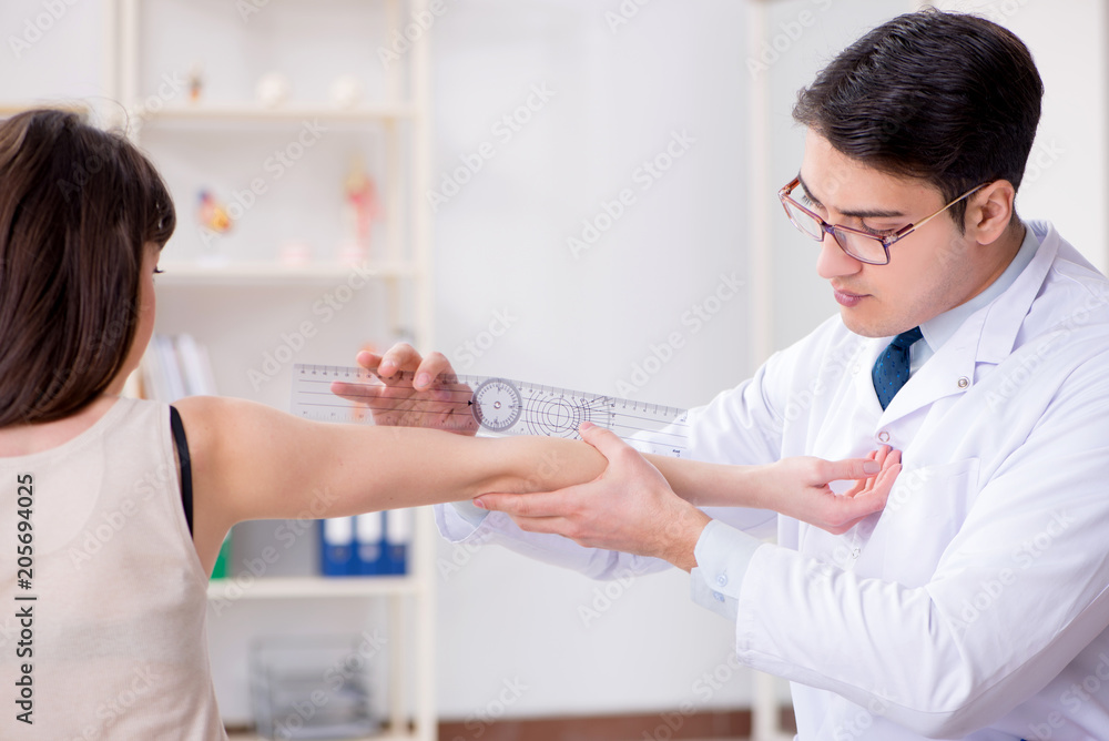 Doctor checking patients joint flexibility with gonimeter Doctor checking patients joint flexibility with gonimeter