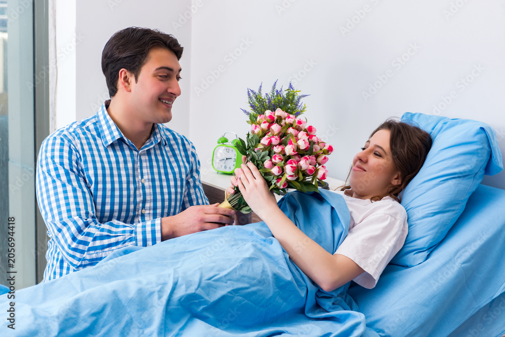 Caring loving husband visiting pregnant wife in hospital Caring loving husband visiting pregnant wife in hospital