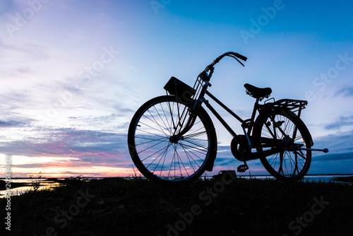 Fototapeta Naklejka Na Ścianę i Meble -  Silhouette bicycle on the hill over sunset background.