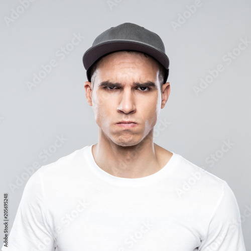 Portrait of angry young man in baseball cap