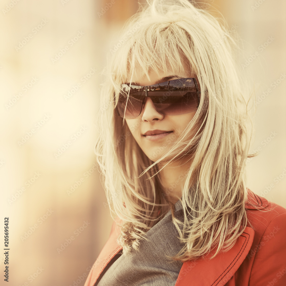 Young fashion business woman in sunglasses walking in city street Young fashion business woman in sunglasses walking in city street