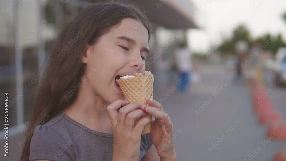 little girl eating ice cream goes down the street in the city next to the supermarket with a soft toy lifestyle motion slow motion video . girl and ice cream urban eat concept little girl eating ice cream goes down the street in the city next to the supermarket with a soft toy lifestyle motion slow motion video . girl and ice cream urban eat concept