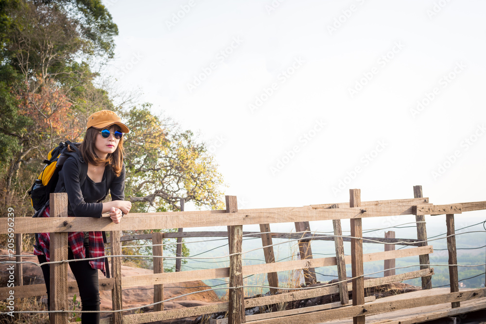 Tourist young woman wearing hat enjoying stand in wood bridge on the mountains. Tourist young woman wearing hat enjoying stand in wood bridge on the mountains.