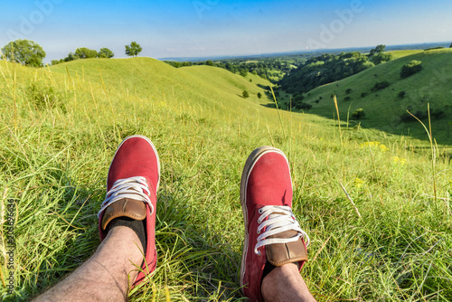 Man relaxing and watching beauthiful landscape with green hills photo