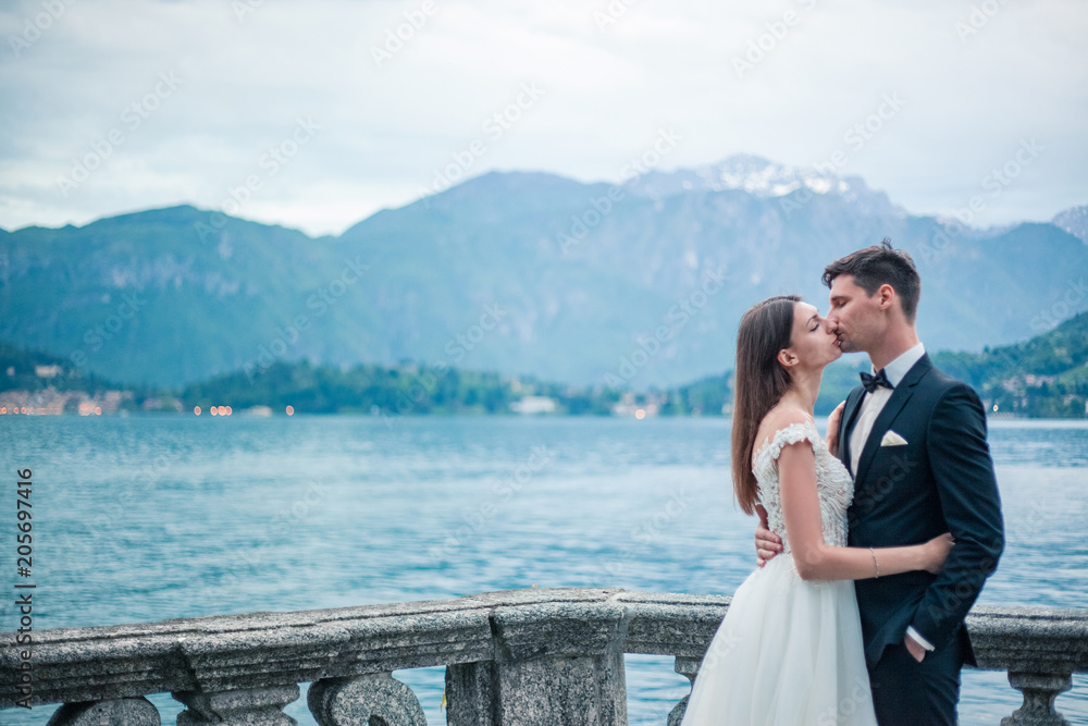 wedding couple kissing on the background of a lake and mountains wedding couple kissing on the background of a lake and mountains