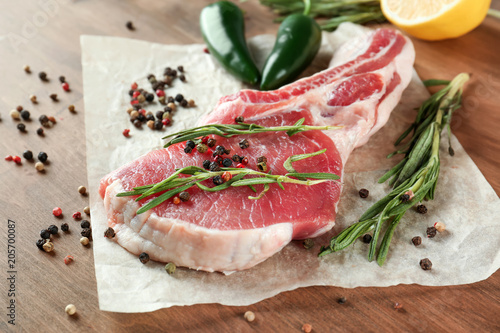 Fresh raw pork rib with spices on wooden table