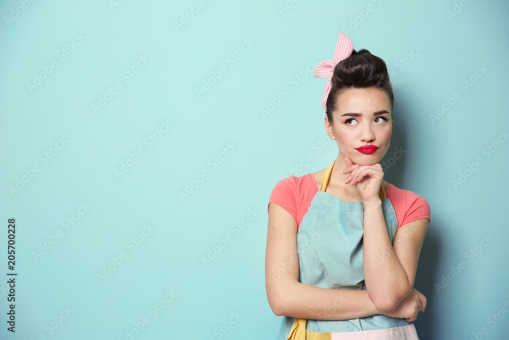 Φωτογραφία Portrait of funny young housewife on color background