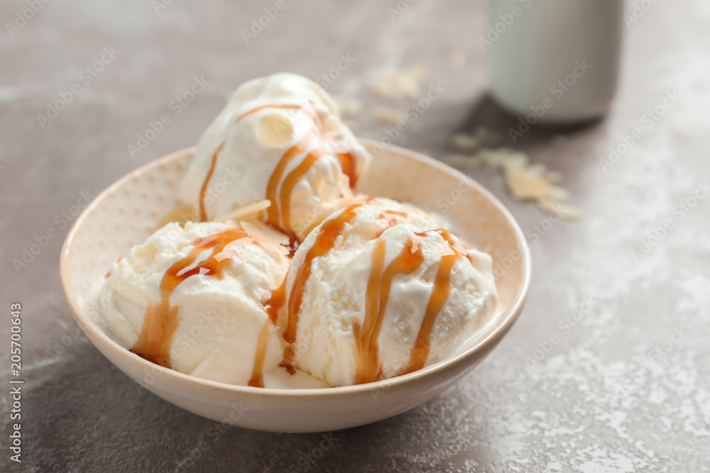 Tasty ice cream with caramel sauce in bowl on table Tasty ice cream with caramel sauce in bowl on table
