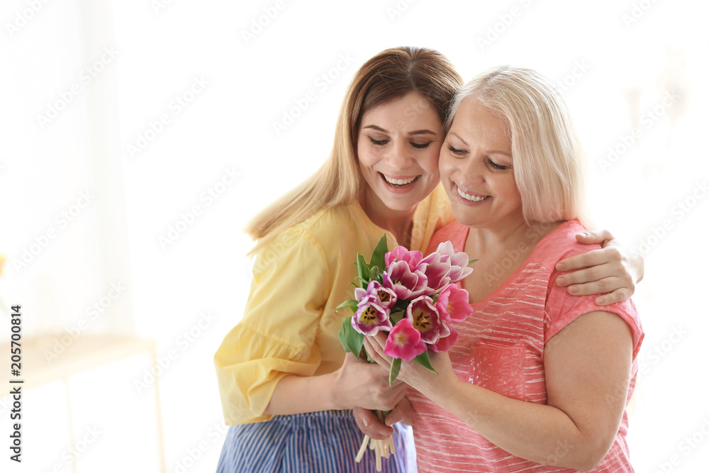 Daughter congratulating happy mature woman on Mother's Day at home Daughter congratulating happy mature woman on Mother's Day at home