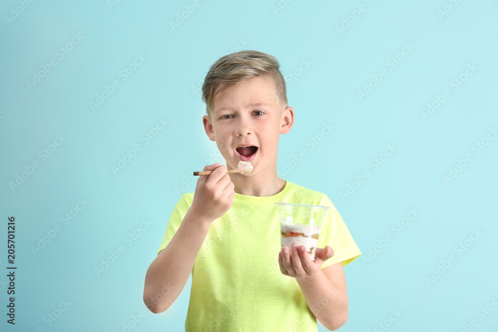 Little boy with yogurt on color background Little boy with yogurt on color background